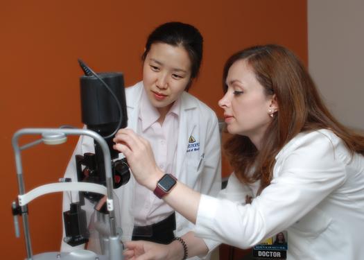 doctors looking at a retinal camera.